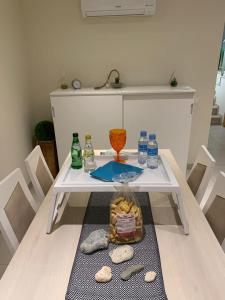 - une table blanche avec des bouteilles au-dessus dans l'établissement Oasis Praia Carvoeiro Bay, à Carvoeiro