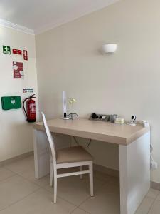 - un bureau dans une chambre avec une chaise à côté dans l'établissement Oasis Praia Carvoeiro Bay, à Carvoeiro