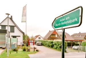 a green street sign in front of a house at Hotel am Müritz-Nationalpark in Waren