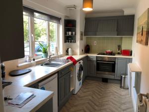 a kitchen with a sink and a washing machine at The Grey Cottage in Blackford