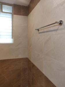 a bathroom with a tiled wall and a window at Studio Apartment by Leela Homes in Arpora