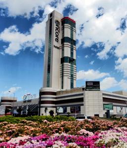 a large building with flowers in front of it at Ramada Encore by Wyndham Izmir in Izmir