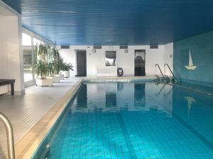 a large swimming pool with blue tiles in a building at Ferienwohnung Watzmannblick & Hallenbad in Berchtesgaden