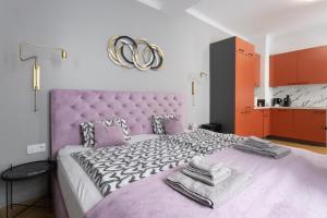 - une chambre avec un lit violet et des serviettes dans l'établissement Old Town Vienna, à Vienne