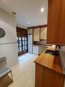a kitchen with wooden cabinets and a wooden floor at 4AgostoPlace in Zaragoza