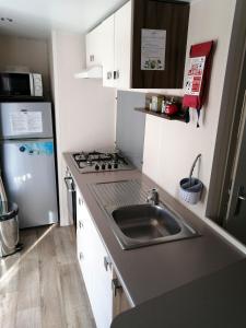 Una pequeña cocina con fregadero y refrigerador. en Bungalow cosy à Onzain avec terrasse & piscine partagée, en Onzain 6 fotos más