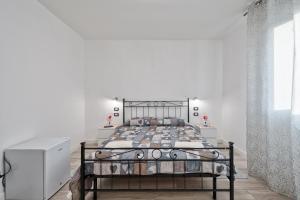 a bedroom with a metal bed in a white room at Venice Pink House in Marghera