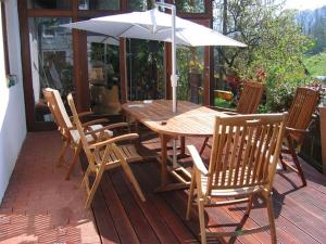 a wooden table and chairs with an umbrella on a deck at Landhaus Wachau in Aggsbach