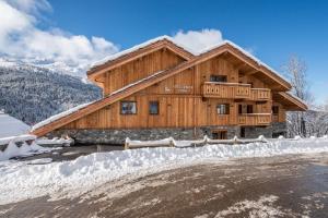 una baita di tronchi nella neve con vialetto di Apartment Ophite Méribel - by EMERALD STAY a Les Allues