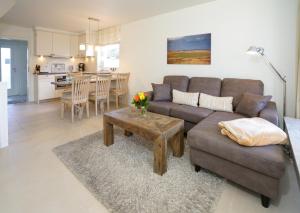 ein Wohnzimmer mit einem Sofa und einem Tisch in der Unterkunft Strandhaus WHG NR 1 "Meer Strand Und Design in Wenningstedt" in Wenningstedt-Braderup