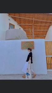 a woman is standing against a white wall at Nhà mình homestay in Mỹ Lại (1)