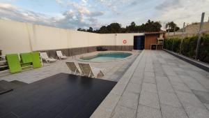 a patio with a pool and chairs and a building at Casinha das Bonecas - Casa com Piscina Privada in Aveiro