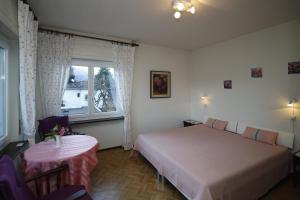 アスコナにあるApartment Casa Thujaのベッドルーム1室(ベッド1台、テーブル、窓付)