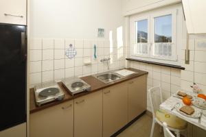 eine kleine Küche mit einer Spüle und einer Theke in der Unterkunft Apartment Casa Thuja in Ascona