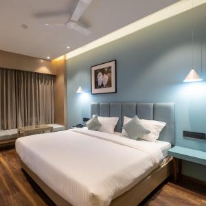 - une chambre avec un grand lit et des draps blancs dans l'établissement Hotel Regal Grand, à Bhopal