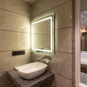 a bathroom with a sink and a mirror at Hotel Regal Grand in Bhopal