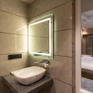 La salle de bains est pourvue d'un lavabo et d'un miroir. dans l'établissement Hotel Regal Grand, à Bhopal