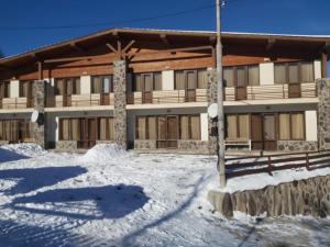 a large building with snow in front of it at Konstantine's Chalet in Bakuriani