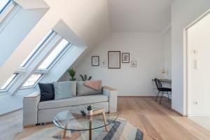 a living room with a couch and a glass table at Sophienne Apartments in Vienna