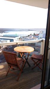 una mesa y sillas en un balcón con vistas a la playa en Comme dans un phare en Arcachón