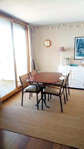 uma sala de jantar com uma mesa de madeira e cadeiras em Comme dans un phare em Arcachon