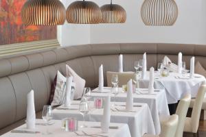 un comedor con mesas y sillas blancas en Best Western Queens Hotel Pforzheim-Niefern, en Pforzheim