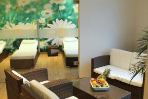 a room with chairs and a table with a bowl of fruit at Best Western Queens Hotel Pforzheim-Niefern in Pforzheim