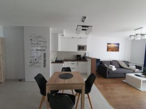 uma cozinha e sala de estar com mesa e cadeiras em Leśna Przystań em Muszyna