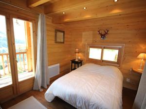um quarto com uma cama num chalé de madeira em Chalet Hauteluce, 7 pièces, 12 personnes - FR-1-293-55 em Hauteluce
