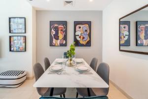 a dining room with a white table and chairs at GuestReady - Jumeirah Lakes View in Dubai