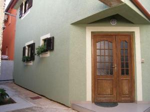 a house with a wooden door on the side of it at Apartment Anni in Pula