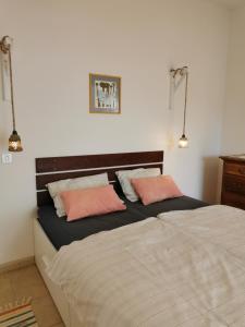 a bedroom with two beds and two pink pillows at Villa Zen in Prizba