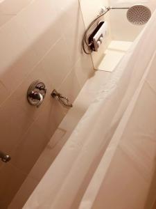 une salle de bain avec douche et distributeur de papier toilette dans l'établissement SMDC Wind Residences Tagaytay by Cris, à Tagaytay