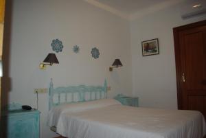 蘭哈龍的住宿－Hotel Lanjaron，卧室配有一张床,墙上有两盏灯