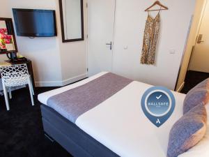Habitación de hotel con cama y TV en ibis Styles Amsterdam City, en Ámsterdam