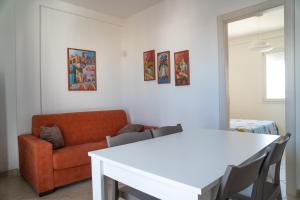 een woonkamer met een witte tafel en een bank bij Casa Vacanza Pirandello in Torre Lapillo