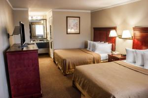 a hotel room with two beds and a flat screen tv at Quality Inn & Suites Fife Seattle in Fife