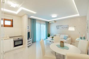 a white living room with a table and a couch at Apartments Dabinovic in Kotor