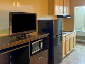 a kitchen with a tv on a counter with a refrigerator at Suburban Studios in Columbia