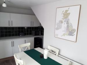 Acer Cottage في Bampton: مطبخ مع طاولة وكراسي في غرفة