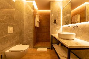 e bagno con servizi igienici, lavandino e doccia. di Mövenpick Hotel Lalez Durres a Durrës