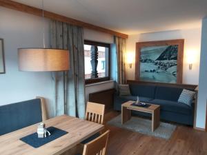 a living room with a table and a blue couch at Haus Rita in Berwang