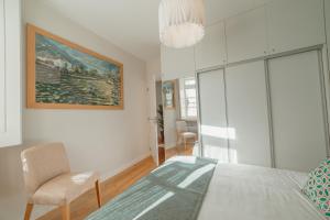 - une chambre avec un lit, une chaise et un tableau dans l'établissement River Eyes Apartments, à Porto