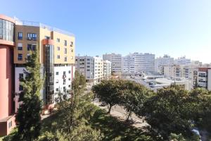 vistas a una ciudad con edificios altos y árboles en Lisbon Flower 360º - Your Lovely Flat with Pool and Parking, en Lisboa