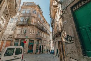 a street with tall buildings and a car parked in front at River Eyes Apartments in Porto
