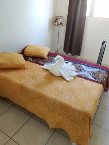 ein weißer Vogel auf einem Bett in der Unterkunft Bas de villa , Résidence Venus calme, vue sur mer in La Trinité