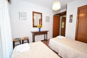 a bedroom with two beds and a table with a mirror at Mariscal I - Fincas Arena in Benidorm