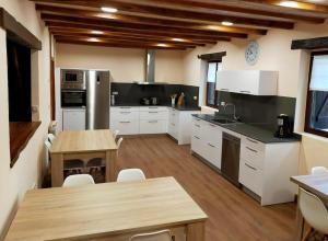 a large kitchen with white cabinets and a wooden floor at Saskarate in Asteasu