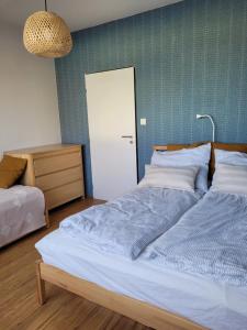 a bedroom with a large bed with a blue wall at Apartmán Spa Šumava in Zdíkov