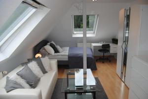 ein Wohnzimmer mit einem Bett und einem weißen Sofa in der Unterkunft Exklusive Villa am Wald mit Garten, Waldzugang und Sauna in Solingen